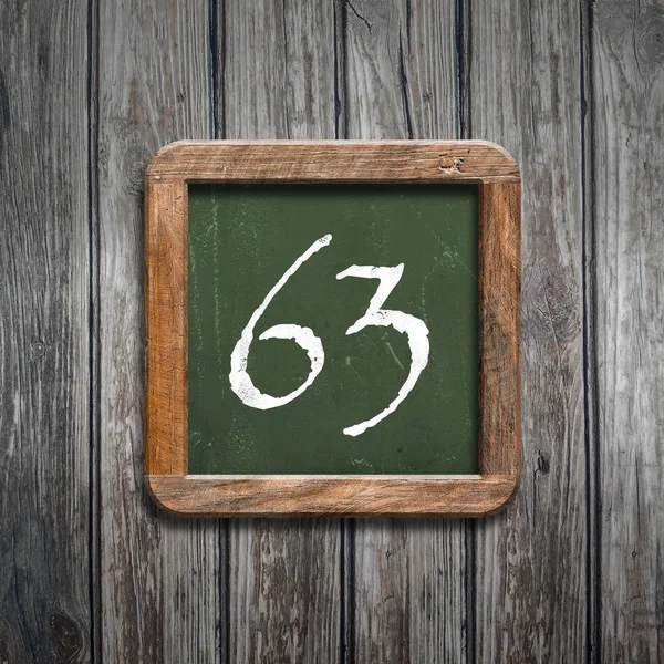 数字63在绿色黑板在木背景之上 — 图库照片