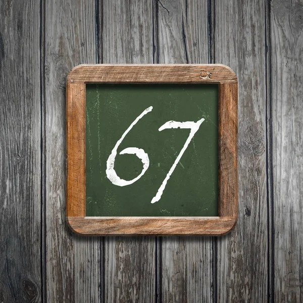 数字67在绿色黑板在木背景之上 — 图库照片