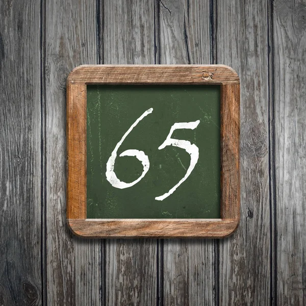数字65在绿色黑板在木背景之上 — 图库照片