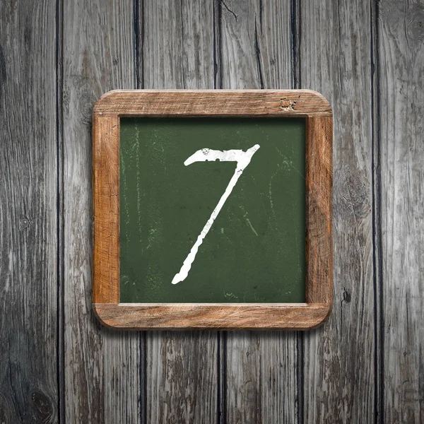 数字7在绿色黑板在木背景之上 — 图库照片