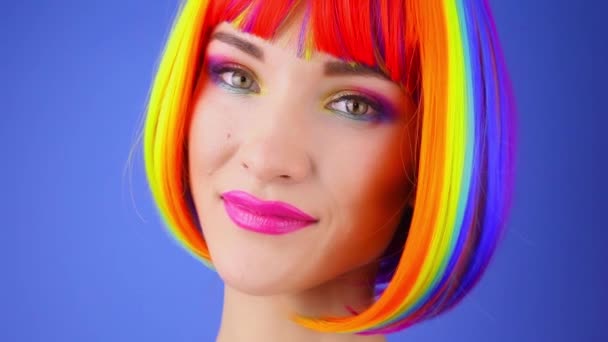 Ung Kvinna Rainbow Färgad Peruk Och Röd Klänning Stående Blå — Stockvideo