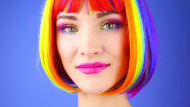Ung Kvinna Rainbow Färgad Peruk Och Röd Klänning Stående Blå — Stockvideo