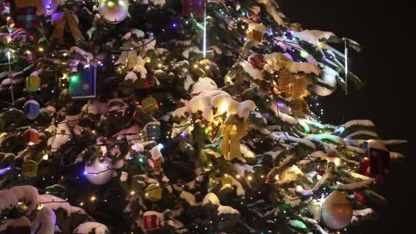 Detailní pohled na vánoční stromeček zdobený sníh, dárky a barevná girlanda