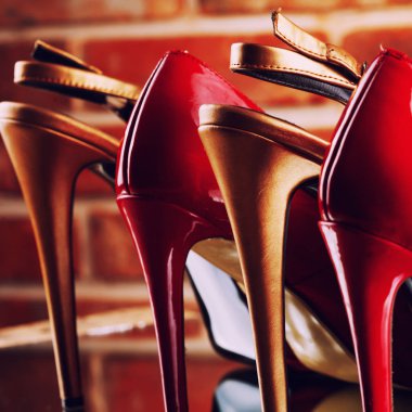 Kırmızı tuğla duvar arka plan üzerinde kırmızı ve altın yüksek topuklu