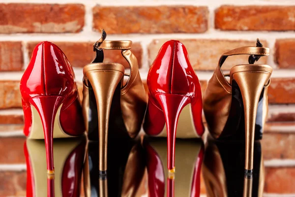 Red and gold high heels on the red brick wall background