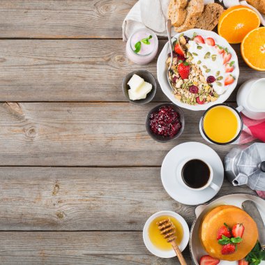 Yiyecek ve içecek, sağlıklı sabah beslenme kavramı. Gözleme, gözleme, kruvasan sandviç ve granola ahşap masanın üzerine yoğurtlu kahvaltı ürün yelpazesine sahip. En iyi görünüm düz yatıyordu kopya alan arka plan