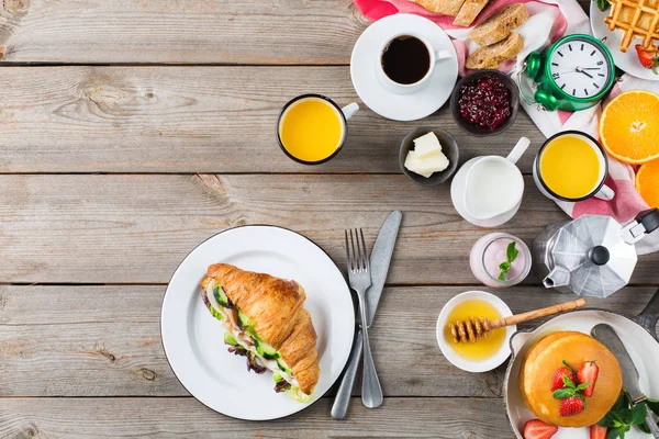 食物和饮料 健康的早晨饮食概念 早餐配有煎饼 华夫饼 牛角面包三明治和燕麦酸奶在木桌上 顶部视图平面放置背景 — 图库照片