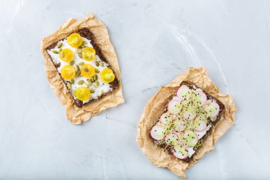 Yiyecek ve içecek, natürmort kavramı. Krem peynir, turp, domates ve mikro Yeşiller lahanası yemek tablo için el yapımı sandviçler çeşitli. Üst görüntülemek düz yatıyordu arka plan