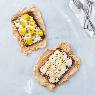 Yiyecek ve içecek, natürmort kavramı. Krem peynir, turp, domates ve mikro Yeşiller lahanası yemek tablo için el yapımı sandviçler çeşitli. Üst görüntülemek düz yatıyordu arka plan