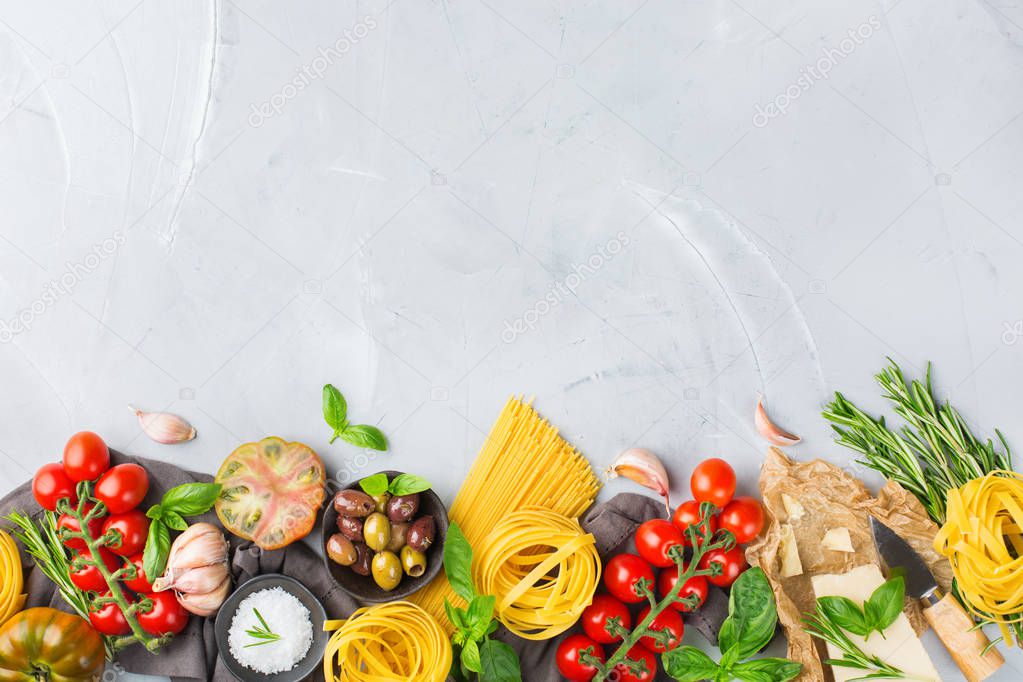 Italian food ingredients cooking background with pasta, olive oil, parmesan cheese, green basil, ripe tomatoes, garlic, herbs. Copy space flat lay top view background