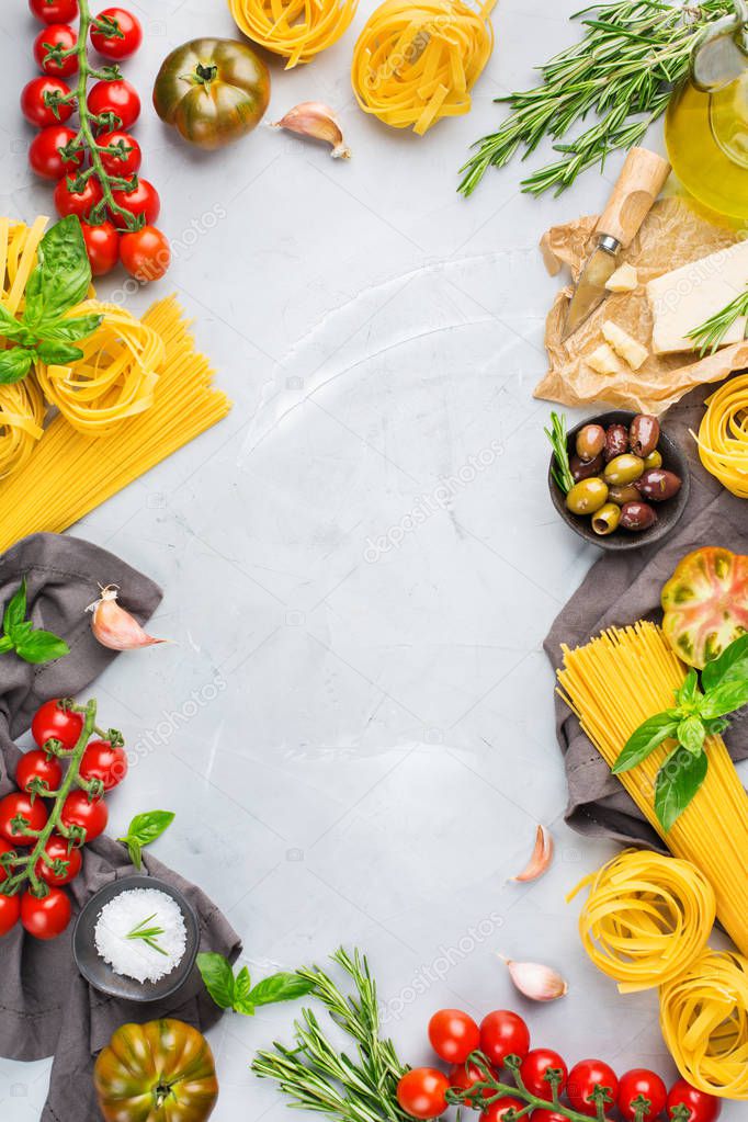 Italian food ingredients cooking background with pasta, olive oil, parmesan cheese, green basil, ripe tomatoes, garlic, herbs. Copy space flat lay top view background