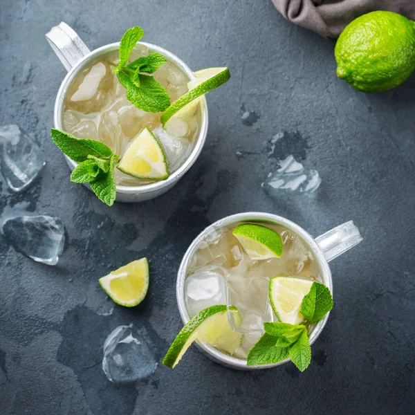 Food and drink, holidays party concept. Cold fresh classic beverage moscow mule cocktail in a silver mug with vodka, ginger beer. lime and mint for refreshment in summer days. Top view