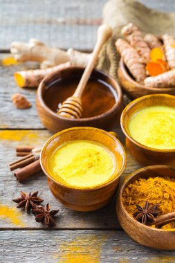 Geleneksel Hint içki zerdeçal altın sütlü malzemeler, zencefil, curcuma, tatlım bir rustik ahşap tablo