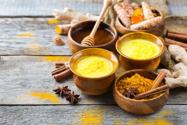 Geleneksel Hint içki zerdeçal altın sütlü malzemeler, zencefil, curcuma, tatlım bir rustik ahşap tablo