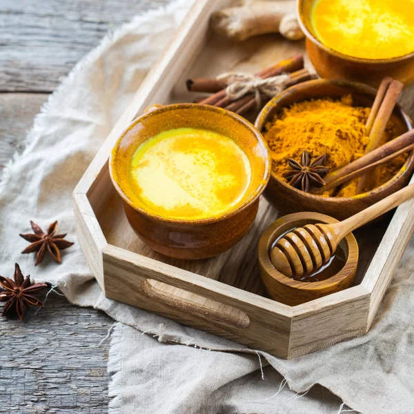 传统的印度饮料姜黄金牛奶配料 蜂蜜在一个质朴的木桌上 — 图库照片