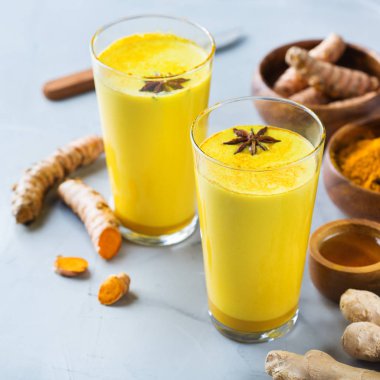 Geleneksel Hint içki zerdeçal altın süt bir cam malzemeler, zencefil, curcuma, mutfak masası bal ile