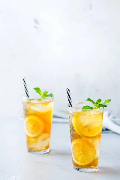 Food and drink, holidays party concept. Lemon mint iced tea cocktail refreshing drink beverage in a glass on a table for summer days. Copy space background