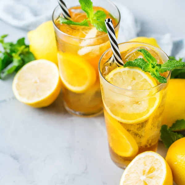 Gıda ve içecek, tatil partisi konsepti. Limon nane bir cam bir tabloda çay kokteyl serinletici içecek içecek yaz günleri için buzlu.