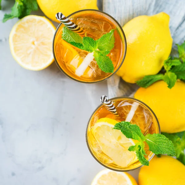 Food and drink, holidays party concept. Lemon mint iced tea cocktail refreshing drink beverage in a glass on a table for summer days. Top view flat lay