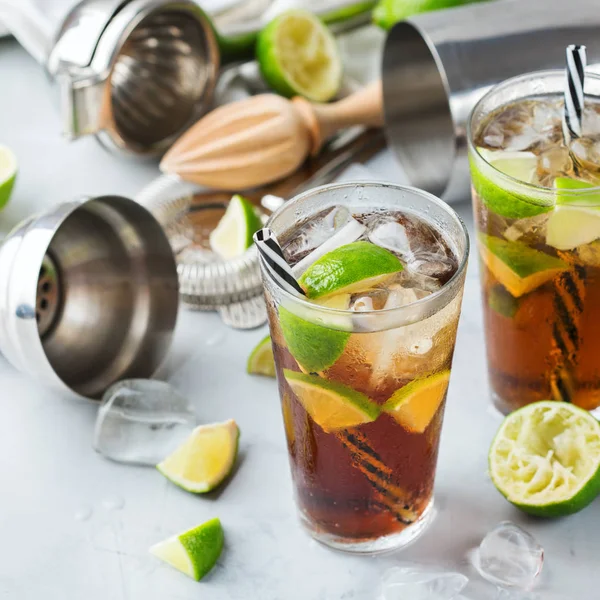 Gıda ve içecek, tatil partisi konsepti. Cuba libre veya long Island buzlu çay alkol kokteyl içki içecek, saman, buz ve limon bir tablo ile bir bardak DRINK