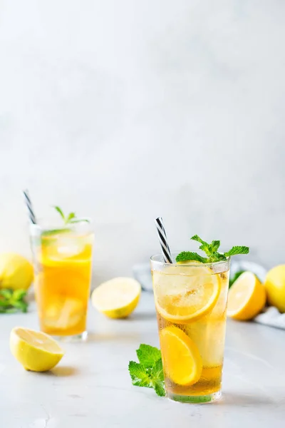 Food and drink, holidays party concept. Lemon mint iced tea cocktail refreshing drink beverage in a glass on a table for summer days. Copy space background