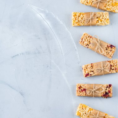 Yiyecek ve içecek, diyet, beslenme kahvaltı kavramı. Sağlıklı ev yapımı Mısır gevreği granola müsli barlar ile yulaf, fındık, Kuru meyveler rahat mutfak masasında. En iyi görünüm düz yatıyordu kopya alan arka plan