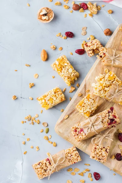 Food and drink, dieting, nutrition breakfast concept. Healthy homemade cereal granola muesli bars with oats, nuts, dry berries on a cozy kitchen table. Top view flat background