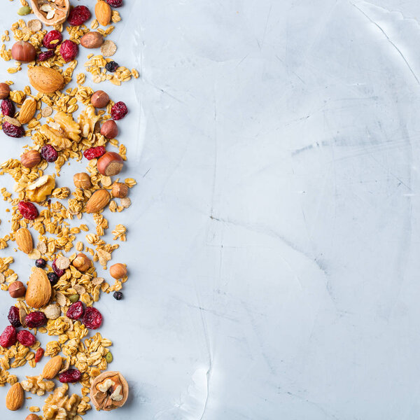 Food and drink, dieting, nutrition breakfast concept. Healthy homemade cereal granola muesli with oats, nuts, dry berries on a cozy kitchen table. Top view flat lay copy space background