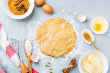 Pişirme malzemeleri ve aletleri mutfak masası üzerinde hamur ile pişirme. Un, şeker, tereyağı, yumurta, baharat, tatlım. En iyi görünüm düz yatıyordu kopya alan arka plan