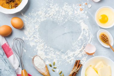 Pişirme malzemeleri ve kalp ile mutfak eşyaları pişirme çerçeve Sevgililer günü için bir mutfak masasında şeklinde. Un, şeker, tereyağı, yumurta, baharat, tatlım. En iyi görünüm düz yatıyordu kopya alan arka plan