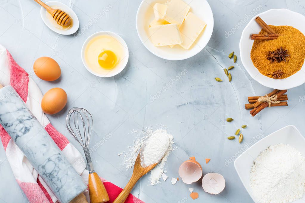 Baking cooking ingredients and utensils on a kitchen table. Flour, sugar, butter, eggs, spices, honey. Top view flat lay copy space background