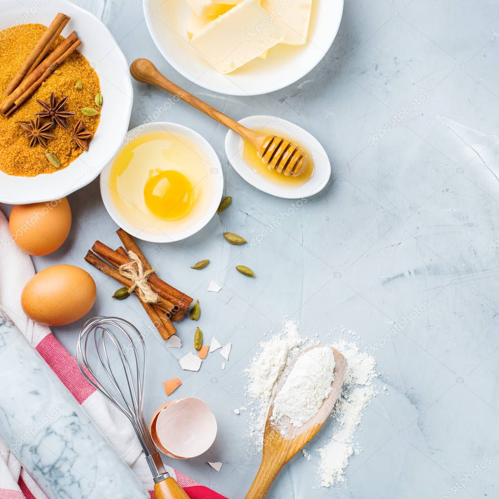 Baking cooking ingredients and utensils with dough on a kitchen table. Flour, sugar, butter, eggs, spices, honey. Top view flat lay copy space background