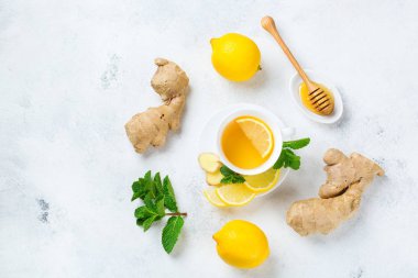 Yiyecek ve içecek, natürmort sağlık kavramı. Zencefil çay infüzyonu İçecek beyaz fincan limon nane canım kış soğuk ve grip için bir mutfak masasında ile sonbahar gün. Üstten görünüm Kopyala uzay arka plan