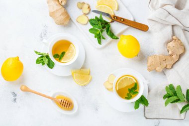 Yiyecek ve içecek, natürmort sağlık kavramı. Zencefil çay infüzyonu İçecek beyaz fincan limon nane canım kış soğuk ve grip için bir mutfak masasında ile sonbahar gün. Üstten görünüm arka plan