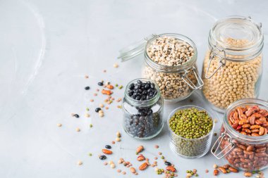 Sağlıklı gıda, diyet, beslenme kavramı, vegan protein kaynağı. Kavanoz, mercimek, soya fasulye, nohut modern mutfak masasında içinde renkli baklagiller ürün yelpazesine. Alan arka plan kopyalama