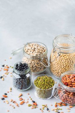 Sağlıklı gıda, diyet, beslenme kavramı, vegan protein kaynağı. Kavanoz, mercimek, soya fasulye, nohut modern mutfak masasında içinde renkli baklagiller ürün yelpazesine. Alan arka plan kopyalama