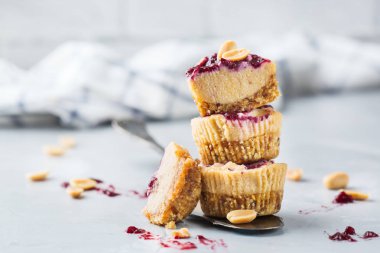 Gıda ve içecek, sağlıklı yaşam, yemek, diyet ve beslenme, Aperatif, superfood kavramı. El yapımı Hayır fırında çiğ vegan protein enerji fıstık ezmesi çubuğu veya cheesecakes mutfak masasında