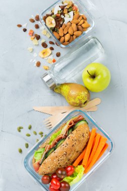 Gıda ve içecek, natürmort, diyet ve beslenme, sağlıklı beslenme, kavram götürün. Sandviç, meyve, sebze, fındık karışımı ve şişe suyu ile beslenme çantası. Üst görüntülemek düz yatıyordu arka plan