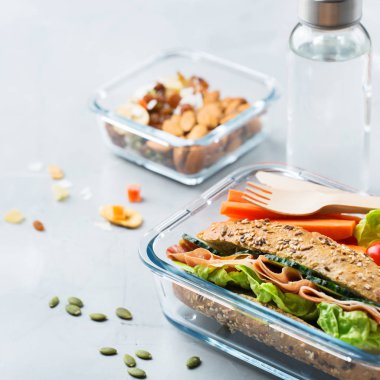 Gıda ve içecek, natürmort, diyet ve beslenme, sağlıklı beslenme, kavram götürün. Sandviç, meyve, sebze, fındık karışımı ve şişe suyu ile öğle yemeği kutusu