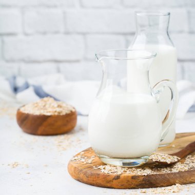 Yiyecek ve içecek, sağlık, diyet ve beslenme kavramı. Ev yapımı organik vegan mutfak masası üzerinde sigara süt yulaf süt