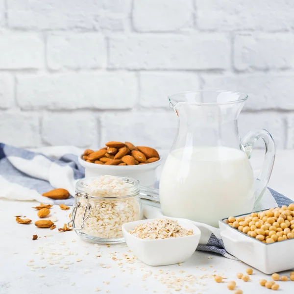 Food and drink, health care, diet and nutrition concept. Assortment of organic vegan non dairy milk from nuts, oat, rice, soy on a kitchen table. Copy space background