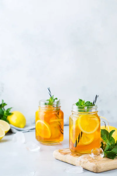 Food and drink, holidays party concept. Lemon mint iced tea cocktail refreshing drink beverage in a mason jar on a table for summer days. Copy space background