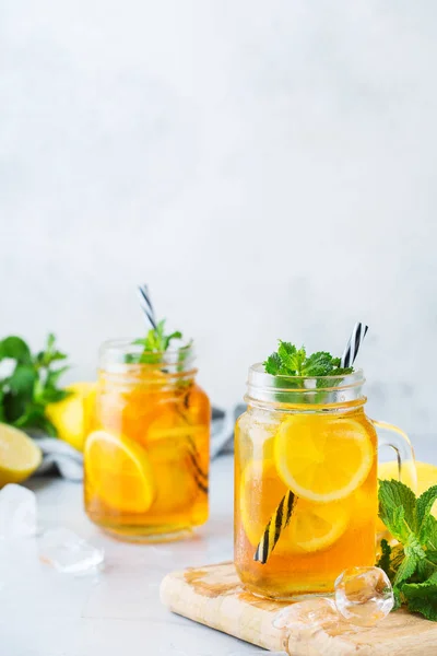 Food and drink, holidays party concept. Lemon mint iced tea cocktail refreshing drink beverage in a mason jar on a table for summer days. Copy space background