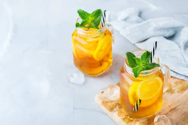 Food and drink, holidays party concept. Lemon mint iced tea cocktail refreshing drink beverage in a mason jar on a table for summer days. Copy space background