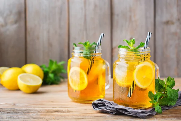 Food and drink, holidays party concept. Lemon mint iced tea cocktail refreshing drink beverage in a mason jar on a table for summer days