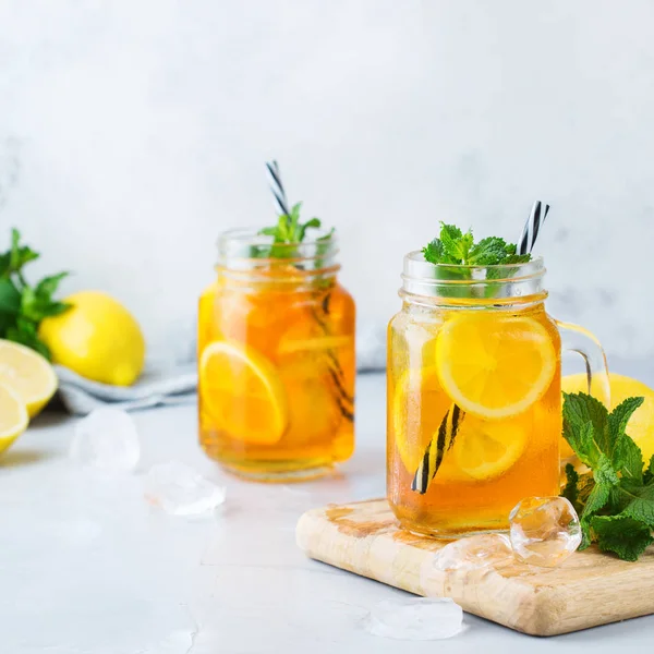 Food and drink, holidays party concept. Lemon mint iced tea cocktail refreshing drink beverage in a mason jar on a table for summer days