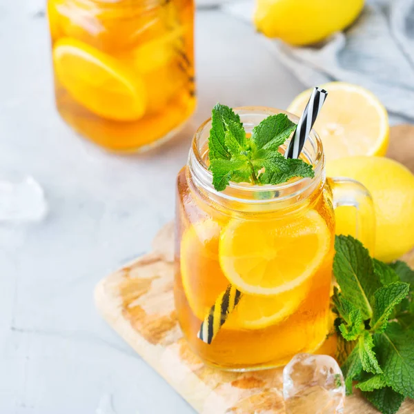 Food and drink, holidays party concept. Lemon mint iced tea cocktail refreshing drink beverage in a mason jar on a table for summer days