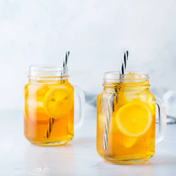 Food and drink, holidays party concept. Lemon mint iced tea cocktail refreshing drink beverage in a mason jar on a table for summer days