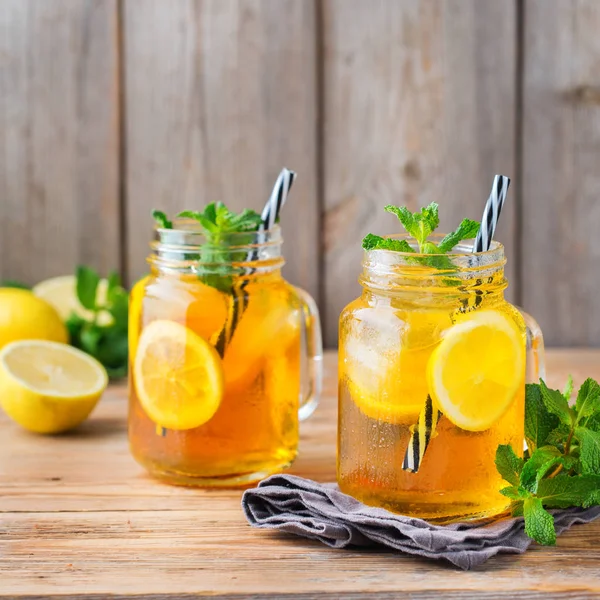 Food and drink, holidays party concept. Lemon mint iced tea cocktail refreshing drink beverage in a mason jar on a table for summer days