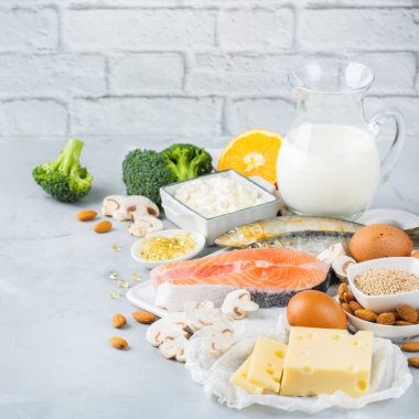 Dengeli beslenme beslenme, sağlıklı beslenme kavramı. Gıda kaynakları zengin vitamin d ve kalsiyum, somon, süt ürünleri, sardalya, brokoli üzerinde mutfak masası çeşitleri